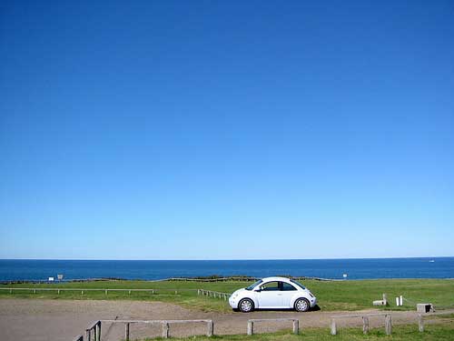 Car at fields and sea, Hokkaido, Japan